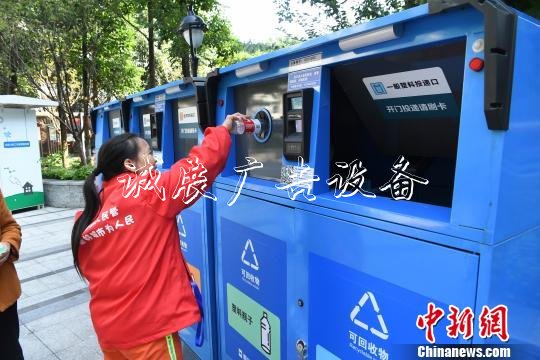 圖為市民展示分類投放垃圾換積分的整個流程?！￡惓?攝
